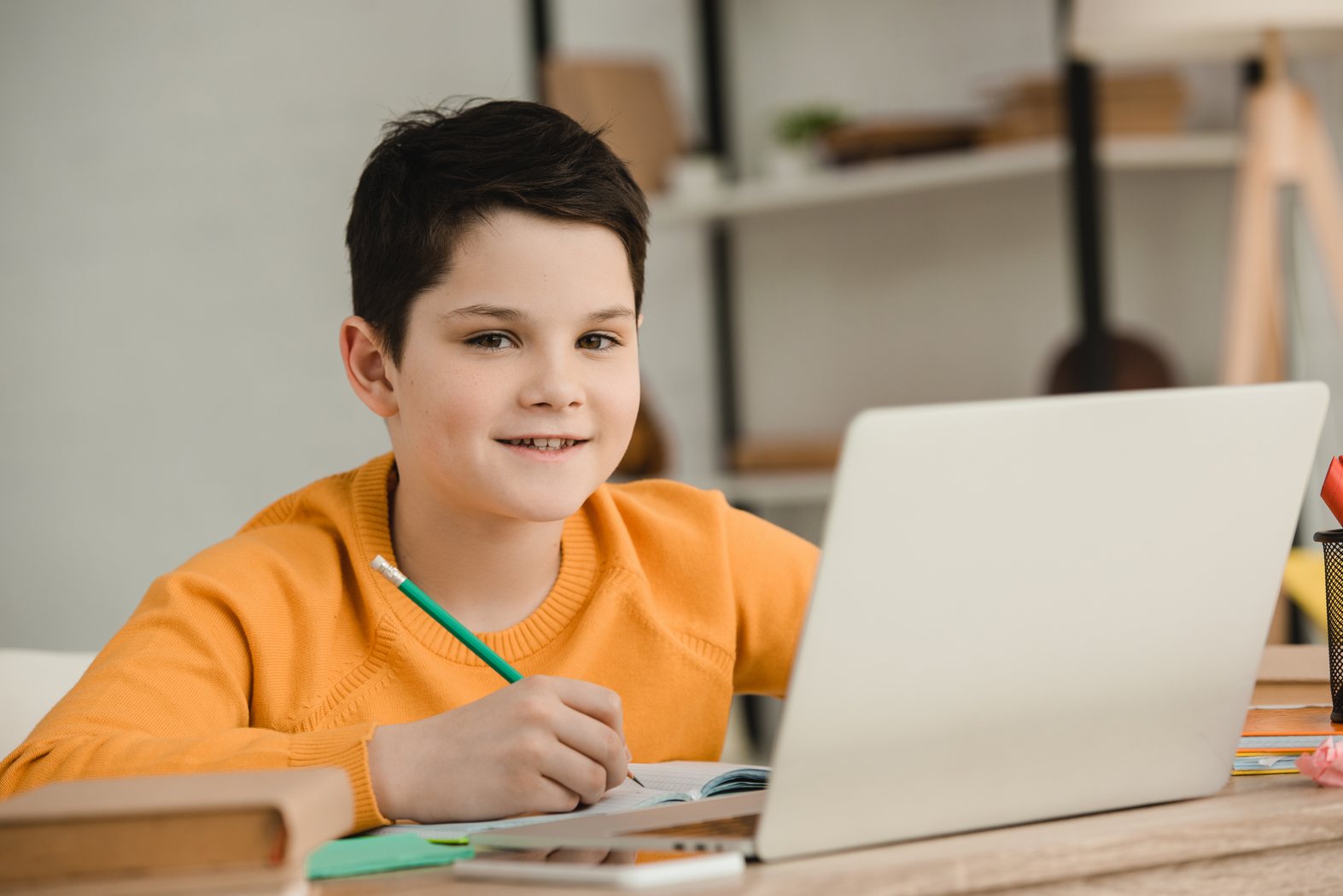 Student using a laptop while completing schoolwork