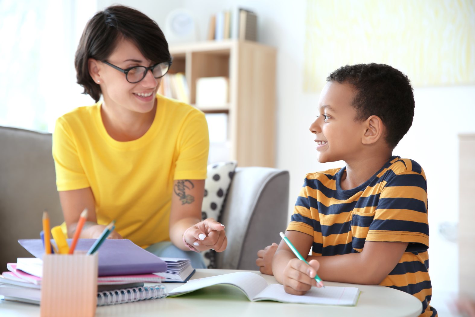 Adult and child smiling during homework support