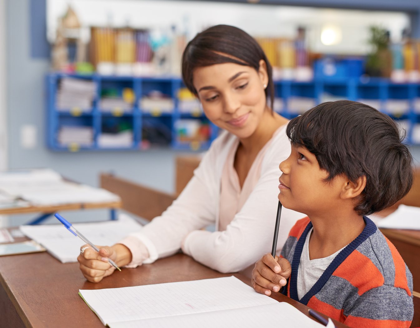 Teacher supporting a student in a classroom
