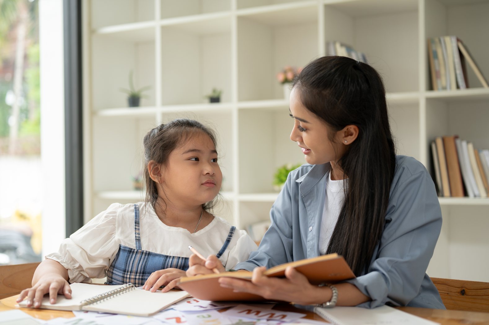 Young student learning with a supportive tutor at home