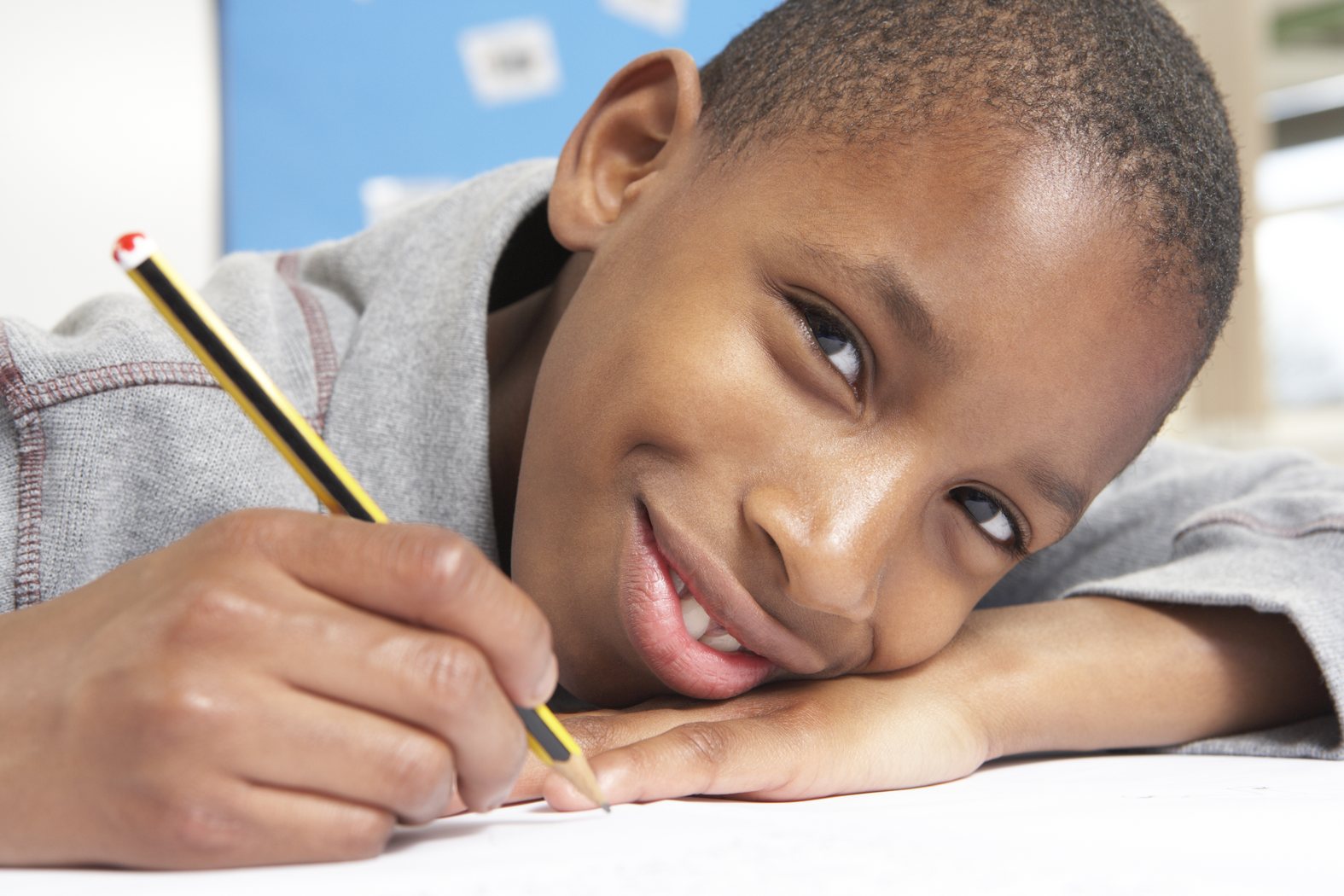 Child writing with a pencil during reading support
